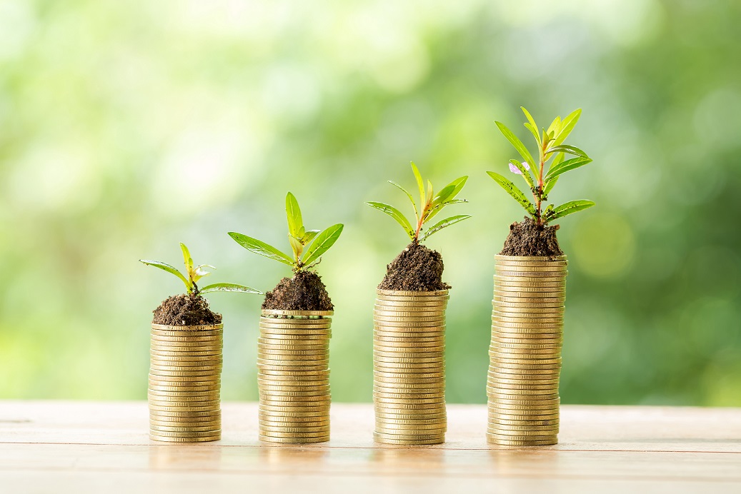 Coin on wooden table in front of green bokeh background. coins a concept of investment and saving moneys.